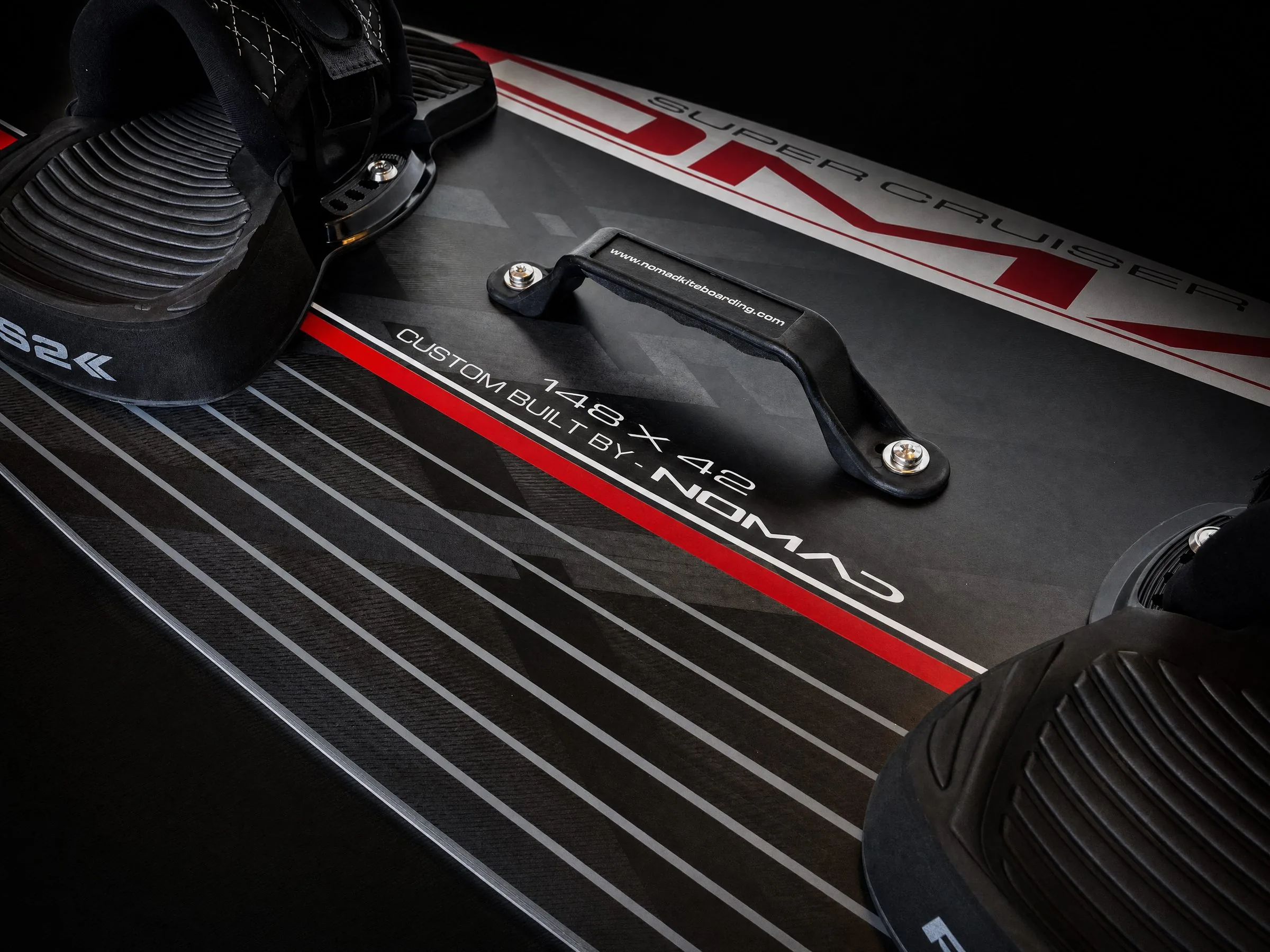 ABS polymer grab handle with rubber under-grip, mounted on a Nomad twin-tip kiteboard deck
