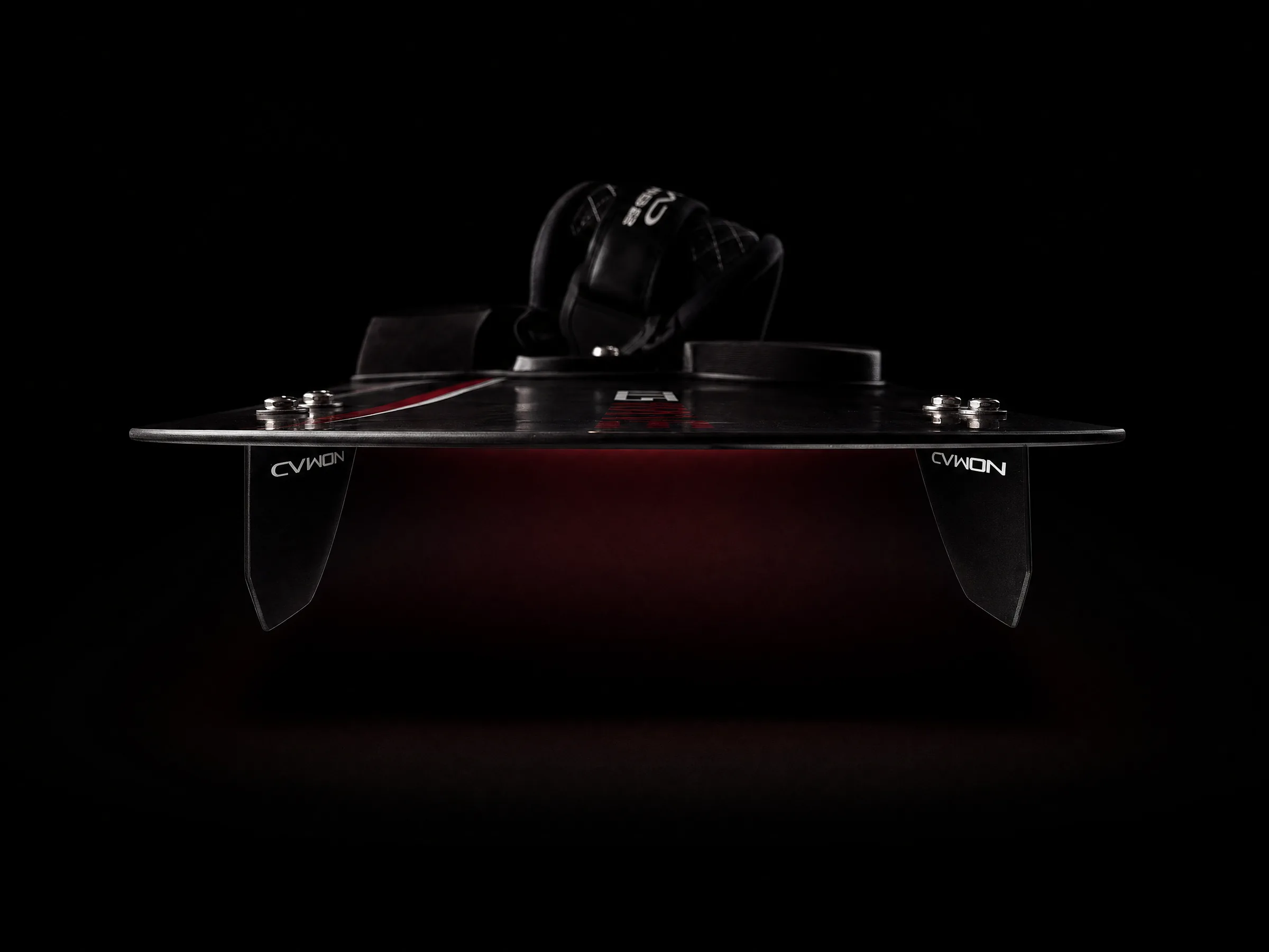 Front-on studio shot of a Nomad wave twin-tip kiteboard underside, showing its dual fin setup and grab handle